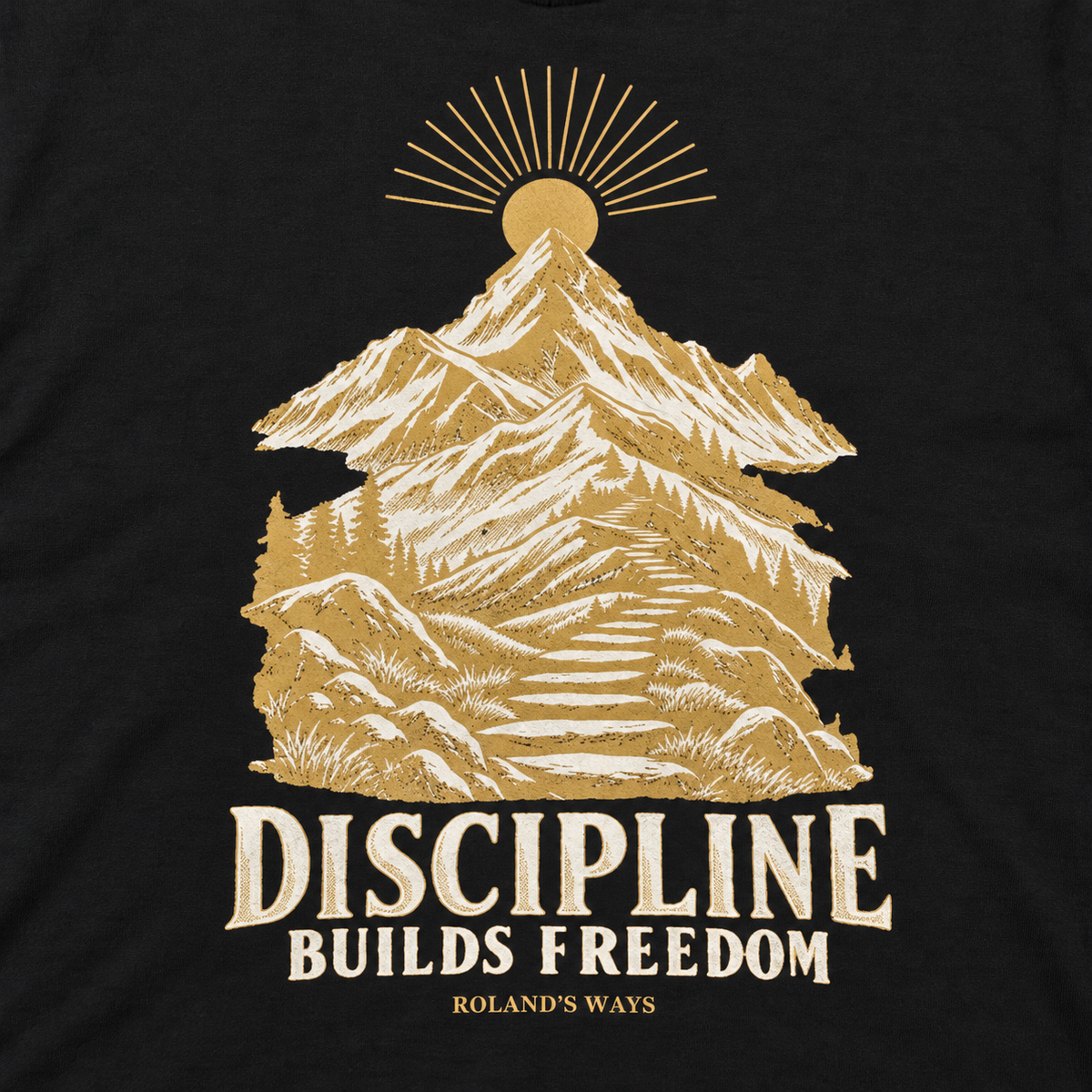 AI close-up mockup of the mountain artwork and slogan on the black Discipline Builds Freedom T-shirt with gold and ivory mountain artwork.
