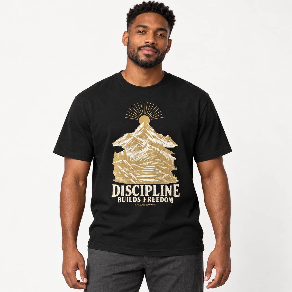 AI studio mockup of a man wearing the black Discipline Builds Freedom T-shirt with gold and ivory mountain artwork.
