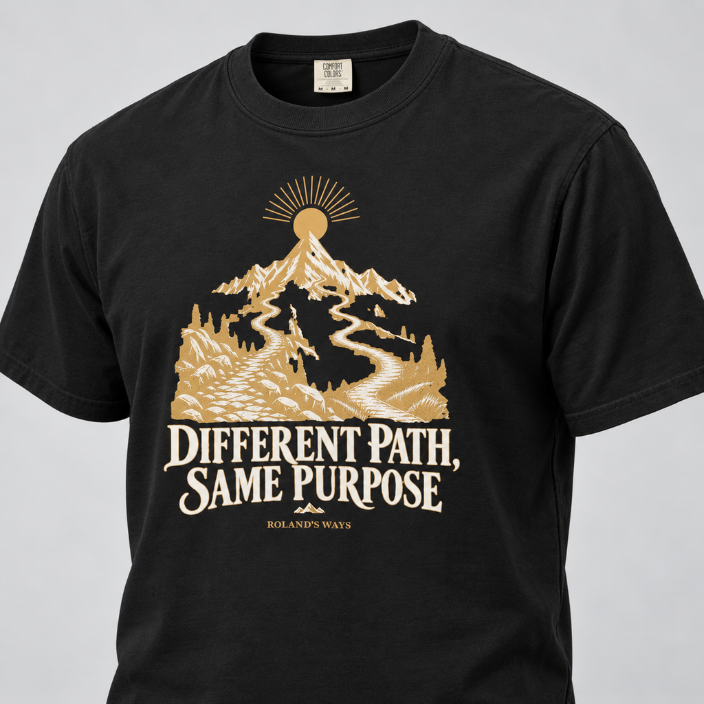 AI angled front mockup of the black Different Path, Same Purpose T-shirt with gold and ivory mountain artwork.