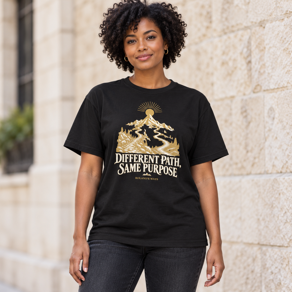 AI urban lifestyle mockup of a woman wearing the black Different Path, Same Purpose T-shirt with gold and ivory mountain artwork.