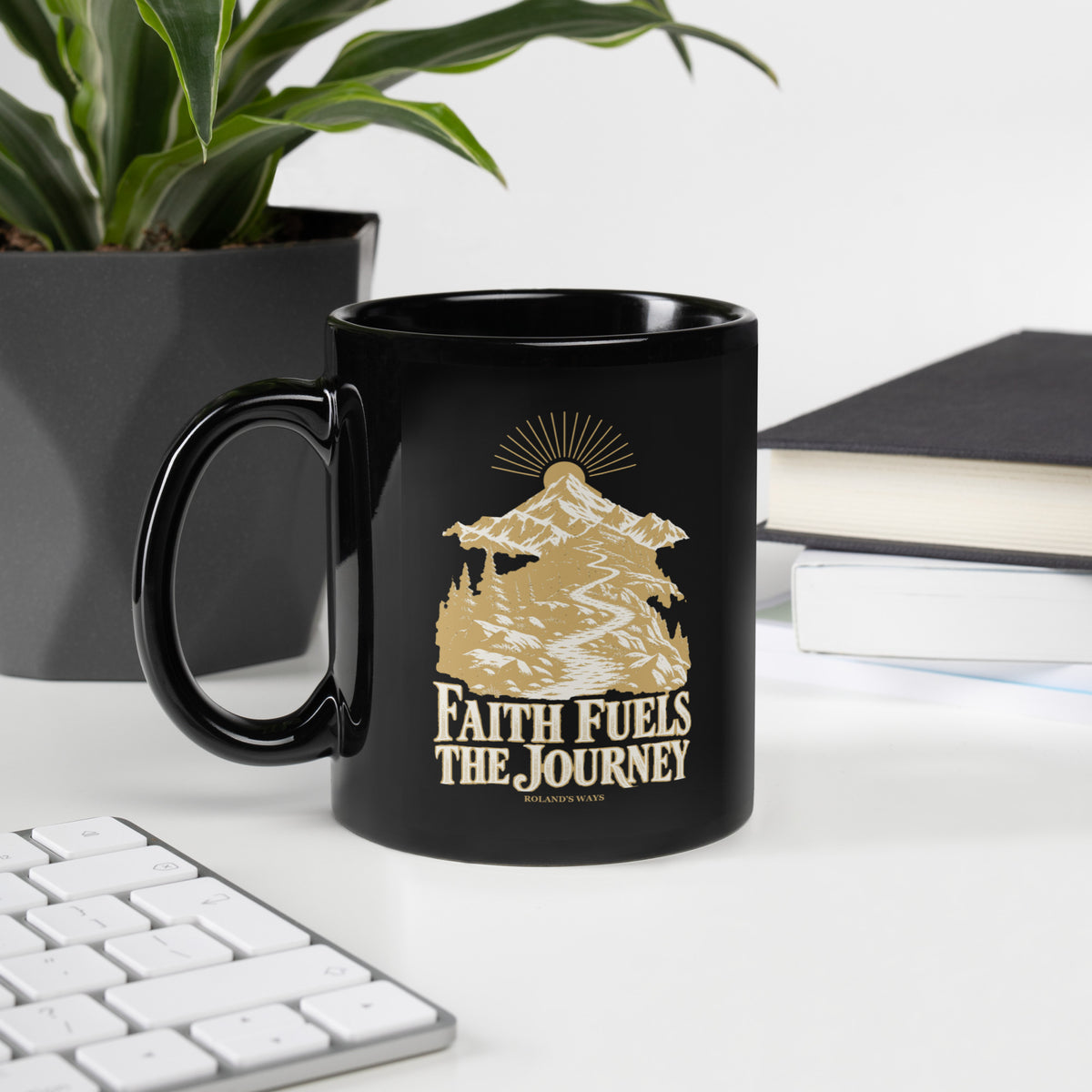 Faith Fuels the Journey Black Glossy Mug in black, with handle on the left with gold and ivory Journey artwork.