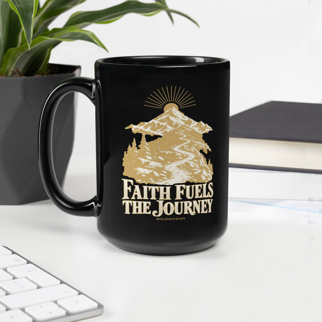 Faith Fuels the Journey Black Glossy Mug in black, with handle on the left with gold and ivory Journey artwork.