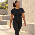 Illustrative lifestyle mockup of a woman wearing the black RW ACTIVE fitted tee.